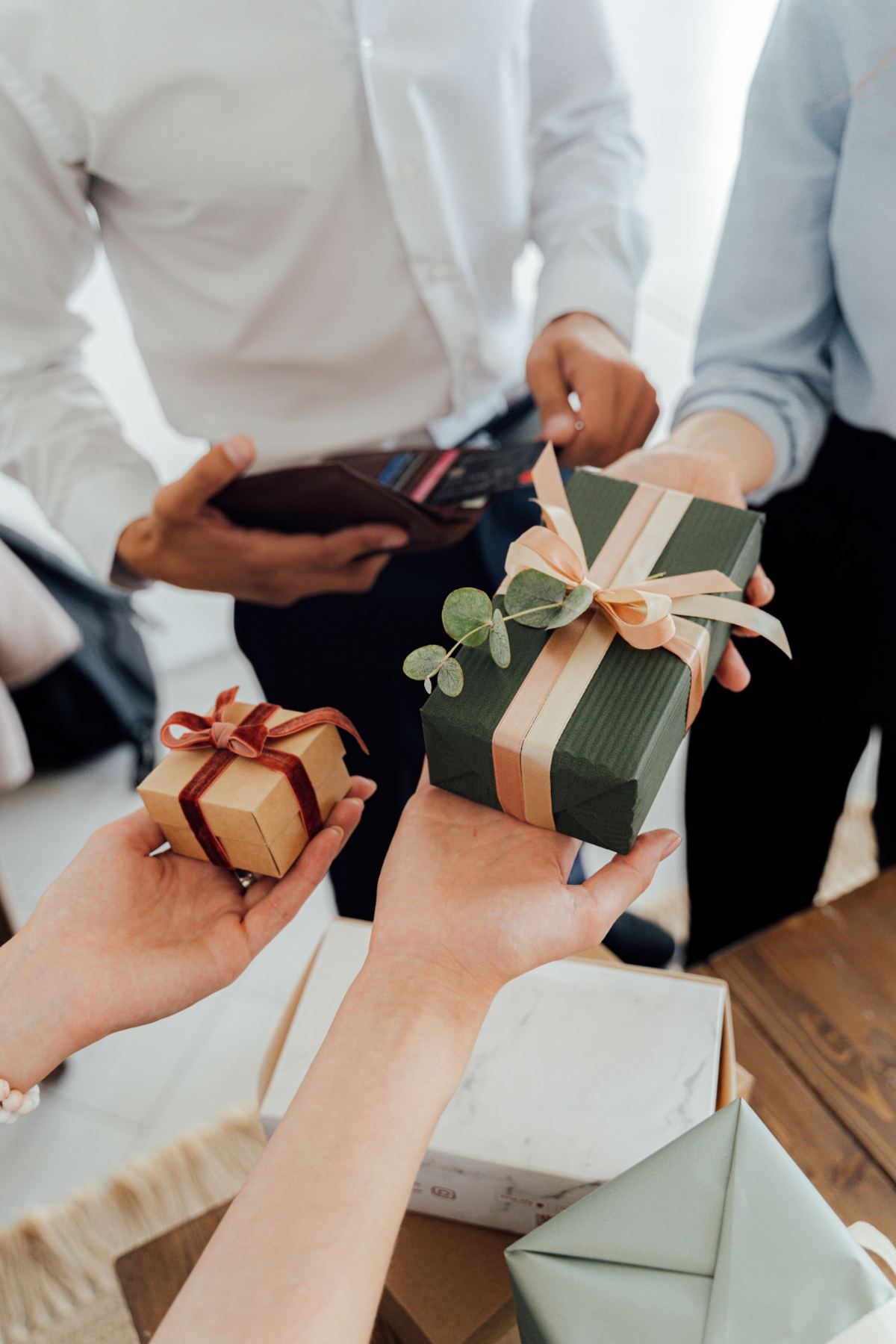 Hands exchanging a wrapped holiday gift